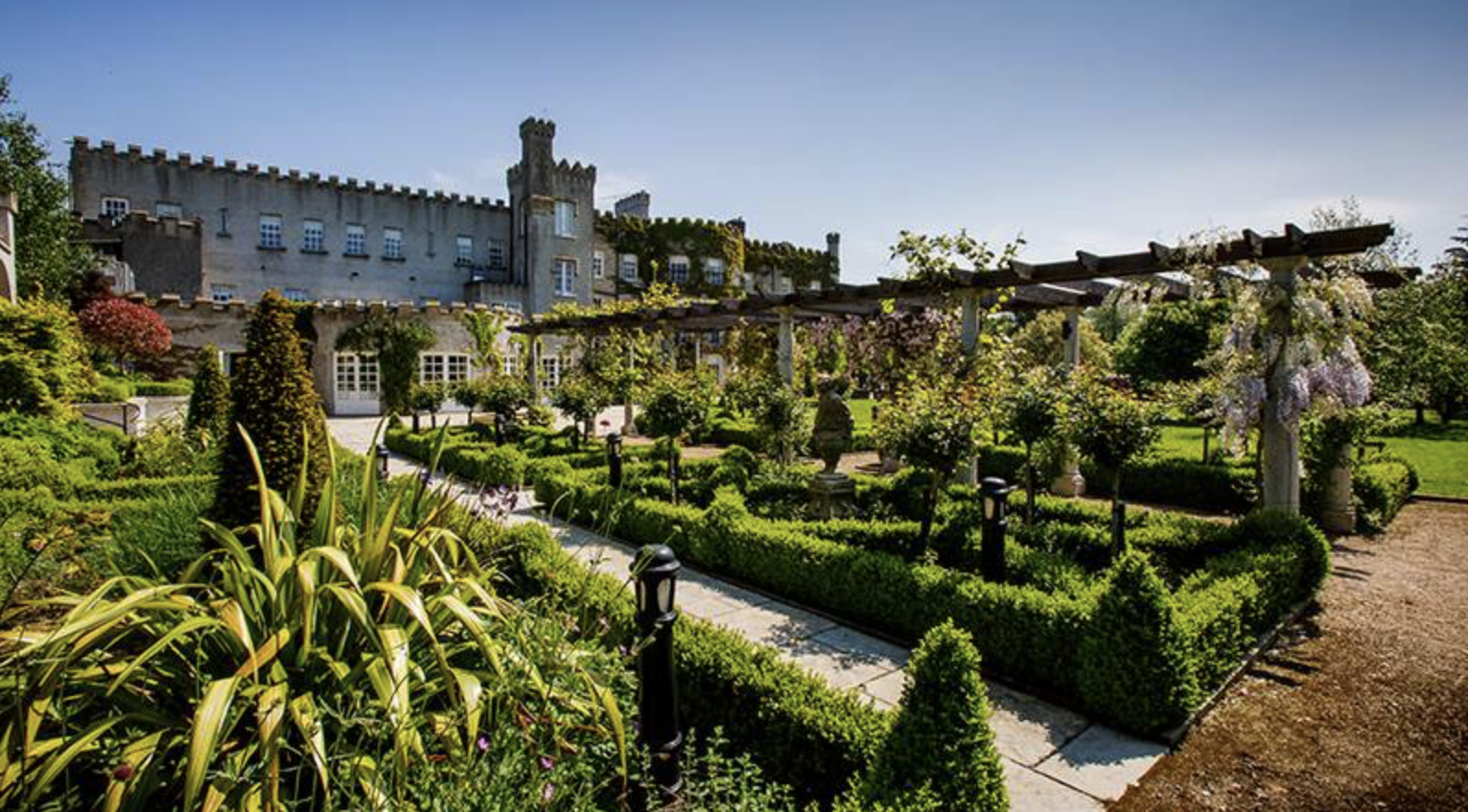 The formal parterre gardens of Bellingham Castle in summer sunshine
